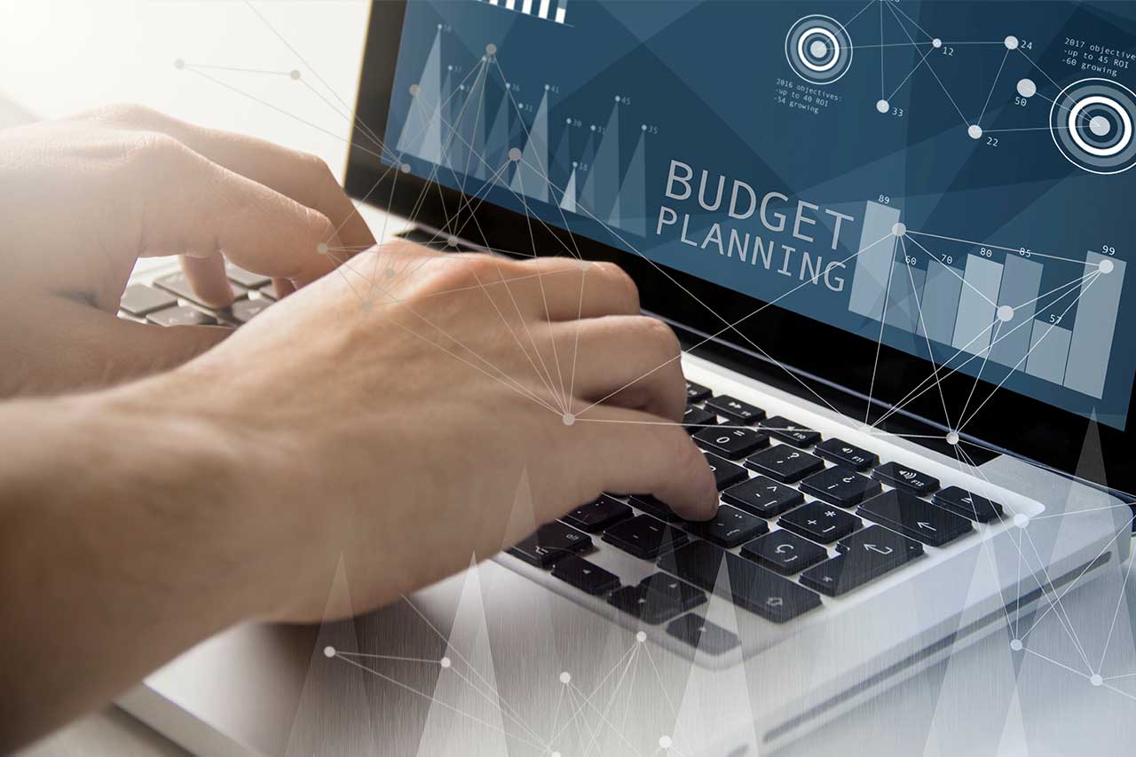 Employee creates budget planning template on laptop.