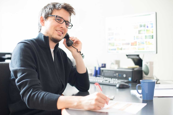 O representante de vendas faz uma chamada telefónica para o cliente potencial como parte da sua gestão de ofertas.