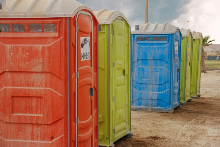 Разноцветные туалеты на пыльном полу
