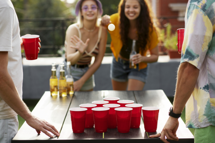 Os amigos jogam beer pong juntos